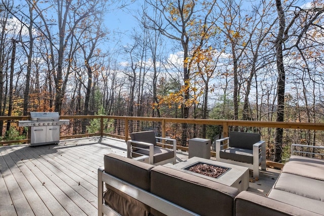 wooden terrace featuring an outdoor living space with a fire pit and grilling area