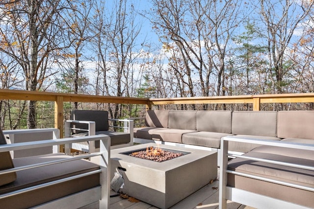 wooden deck featuring an outdoor living space with a fire pit