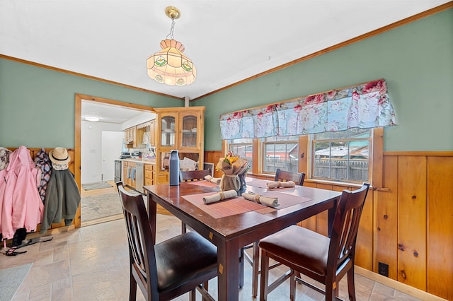 dining room featuring wooden walls and crown molding