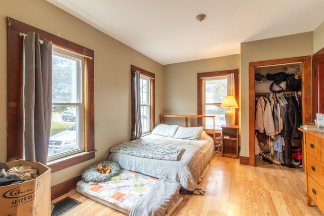 bedroom with light wood-type flooring and a closet