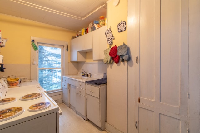 kitchen featuring sink, white electric range, and white cabinets