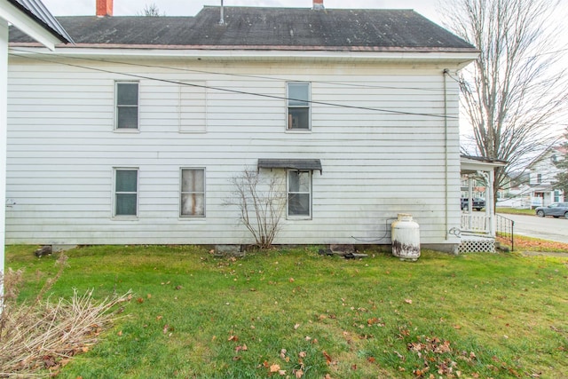 rear view of property featuring a yard