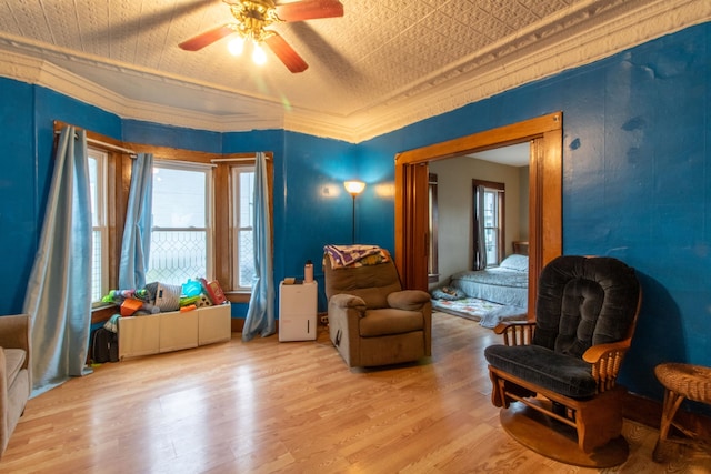 sitting room with ceiling fan, crown molding, and light hardwood / wood-style flooring