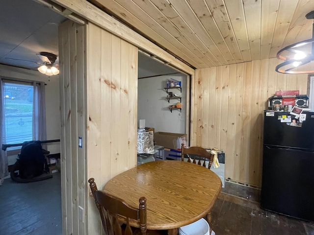 dining space featuring wooden walls, ceiling fan, and wood ceiling