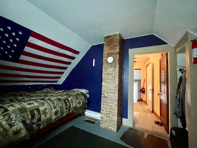 bedroom with hardwood / wood-style flooring and vaulted ceiling