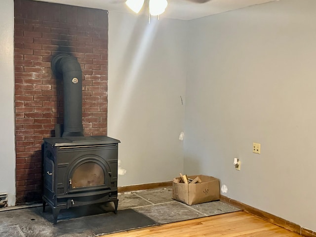 details featuring hardwood / wood-style flooring, ceiling fan, and a wood stove