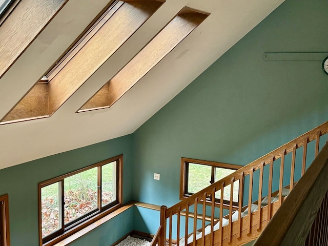 stairway featuring vaulted ceiling with skylight