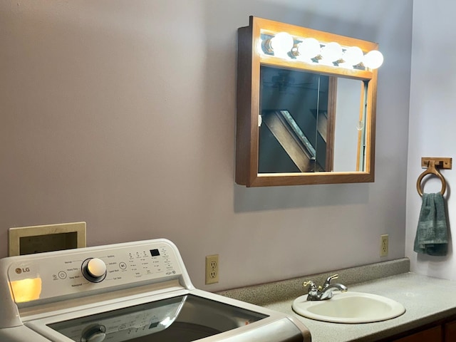 clothes washing area featuring sink and washer / dryer