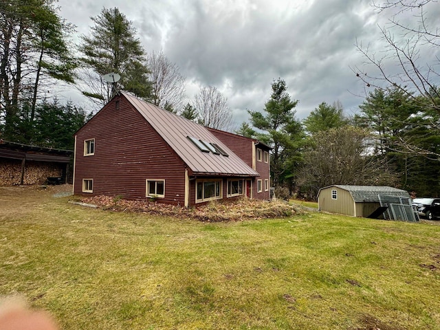 back of house with a shed and a yard