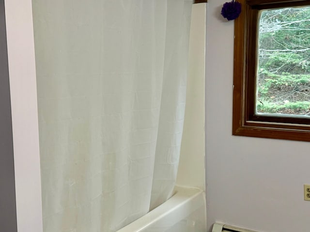 bathroom with shower / bathtub combination with curtain, baseboard heating, and plenty of natural light