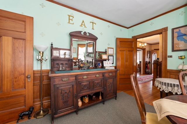 bar with wood-type flooring, wooden walls, crown molding, and a notable chandelier