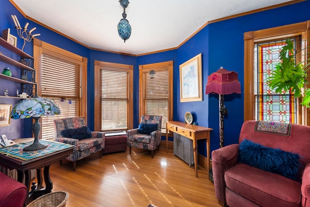 sitting room featuring ornamental molding and wood-type flooring