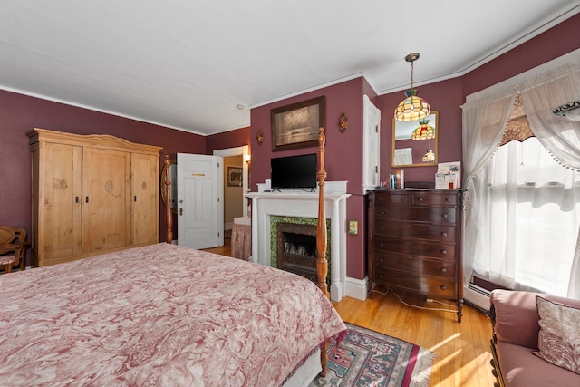 bedroom featuring ornamental molding and light hardwood / wood-style floors