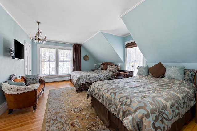 bedroom with an inviting chandelier, multiple windows, vaulted ceiling, and light hardwood / wood-style flooring