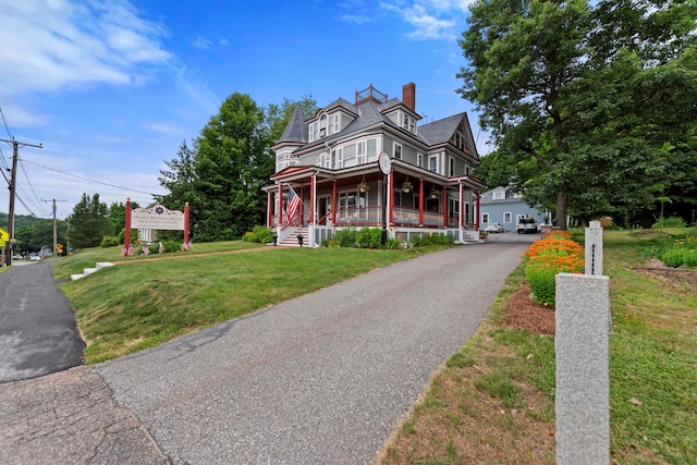 view of front of property featuring a garage, a front yard, and covered porch