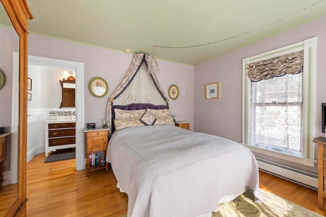 bedroom featuring light wood-type flooring, multiple windows, and a baseboard radiator