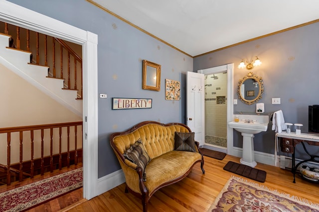 sitting room with hardwood / wood-style floors and crown molding