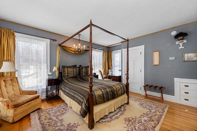 bedroom with light wood-type flooring, multiple windows, and an inviting chandelier