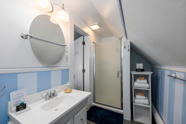 bathroom featuring vanity, lofted ceiling, and a shower with door