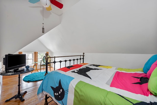 bedroom with hardwood / wood-style floors, ceiling fan, and vaulted ceiling