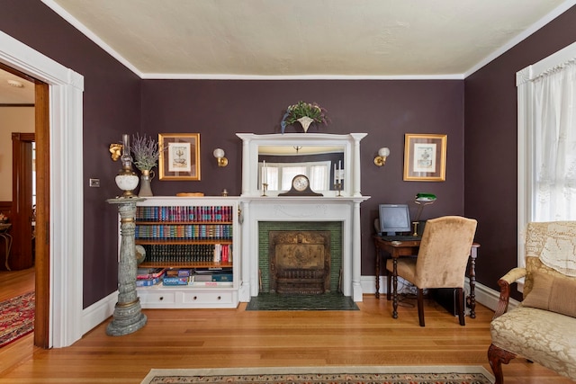 living area featuring hardwood / wood-style flooring and crown molding