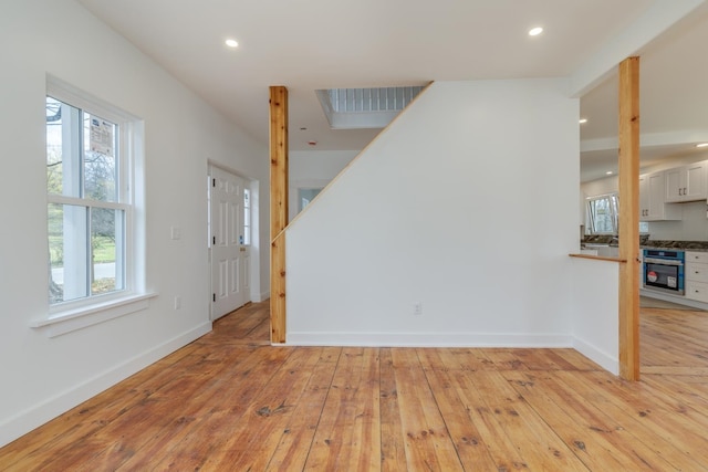 spare room with light wood-type flooring and a wealth of natural light