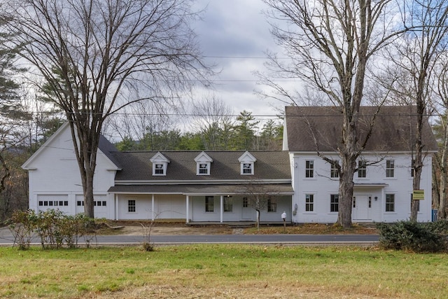 view of front of property with a garage, a front lawn, and covered porch