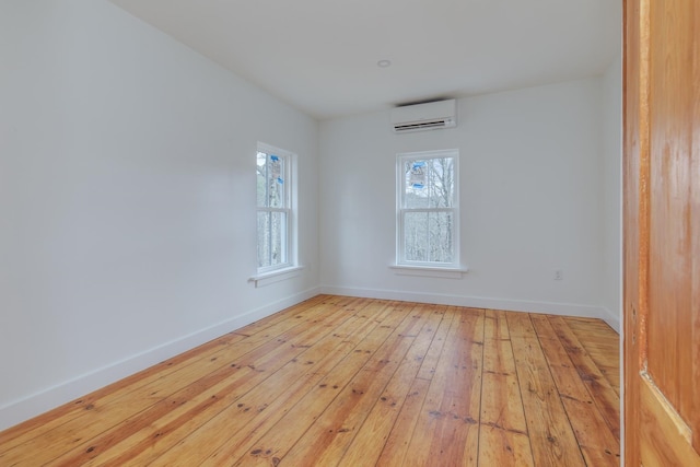 spare room with light hardwood / wood-style floors and a wall mounted air conditioner