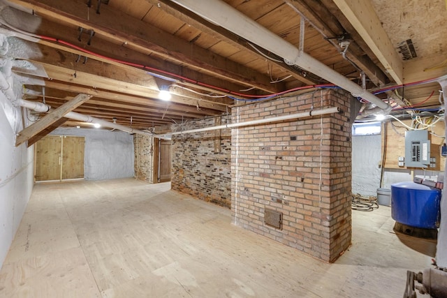 basement with electric panel and brick wall