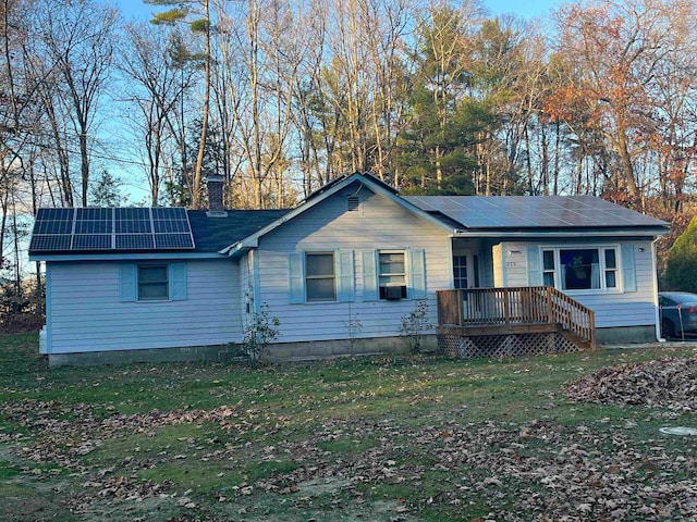 ranch-style home with solar panels and a front lawn