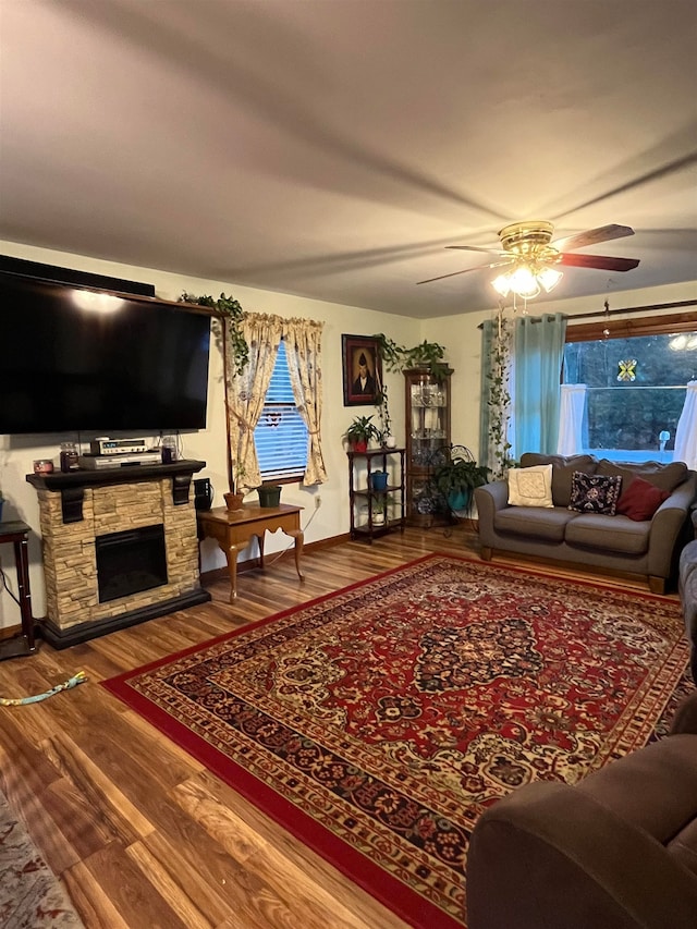 living room with a fireplace, ceiling fan, and hardwood / wood-style floors