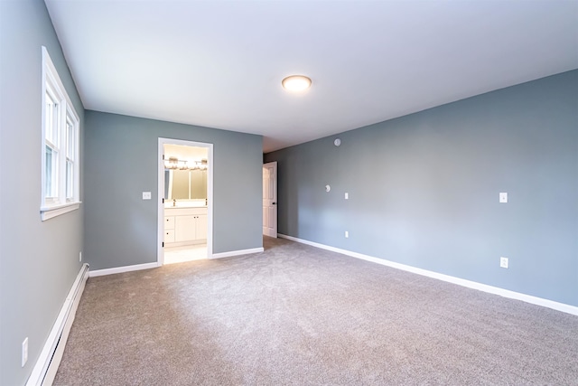 unfurnished bedroom with connected bathroom, carpet flooring, and a baseboard heating unit