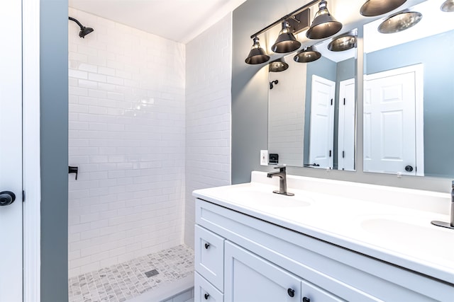 bathroom with vanity and a tile shower