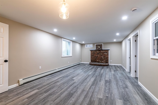 basement featuring dark wood-type flooring, a fireplace, and a baseboard radiator