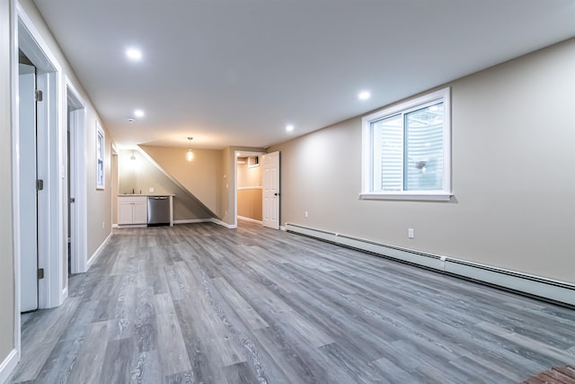 interior space featuring baseboard heating and light hardwood / wood-style flooring