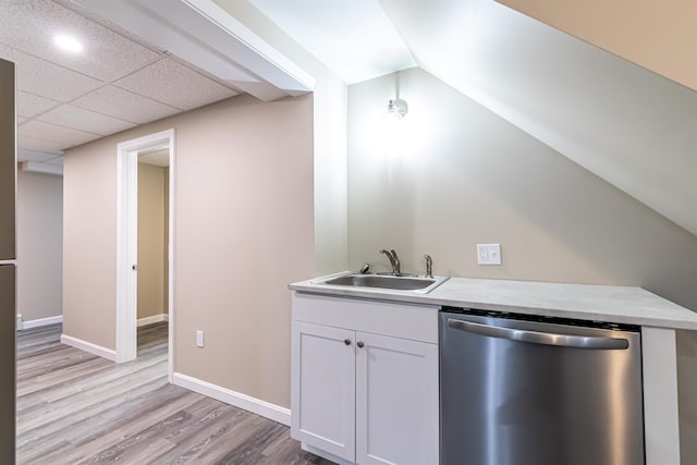 kitchen featuring white cabinetry, sink, stainless steel dishwasher, lofted ceiling, and light hardwood / wood-style flooring