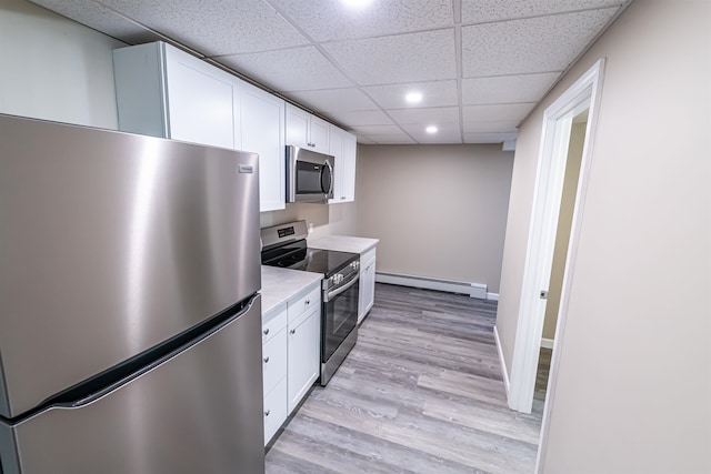 kitchen with a baseboard radiator, light hardwood / wood-style flooring, a paneled ceiling, white cabinetry, and appliances with stainless steel finishes