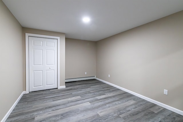 unfurnished bedroom featuring light hardwood / wood-style floors, a baseboard radiator, and a closet