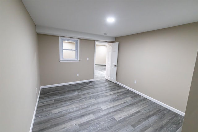 unfurnished room featuring hardwood / wood-style flooring and baseboard heating