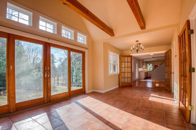 doorway to outside featuring beam ceiling, plenty of natural light, light tile patterned floors, french doors, and a chandelier