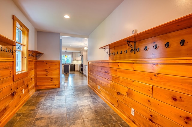 hallway featuring wooden walls