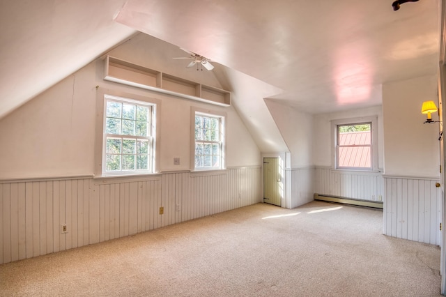 bonus room with light carpet, baseboard heating, and vaulted ceiling