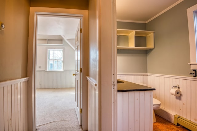 bathroom featuring toilet, vanity, a baseboard heating unit, and ornamental molding