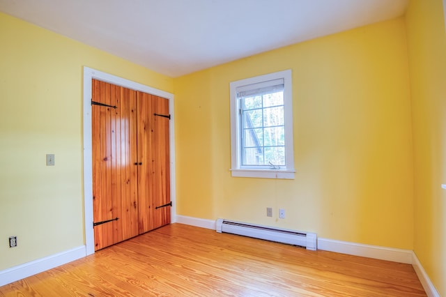 unfurnished bedroom featuring light hardwood / wood-style floors and a baseboard radiator