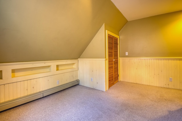 additional living space with a baseboard radiator, light carpet, and vaulted ceiling