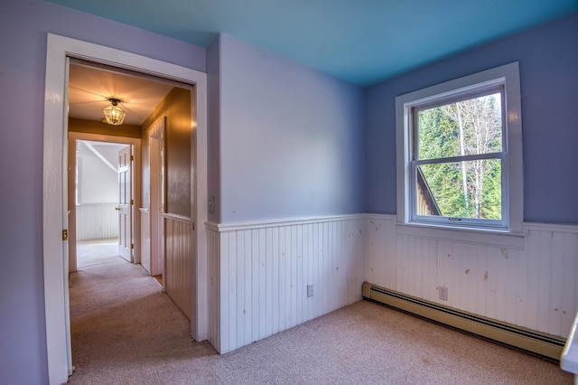 empty room with a baseboard radiator and light carpet