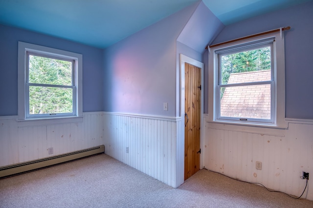 carpeted spare room with baseboard heating and plenty of natural light