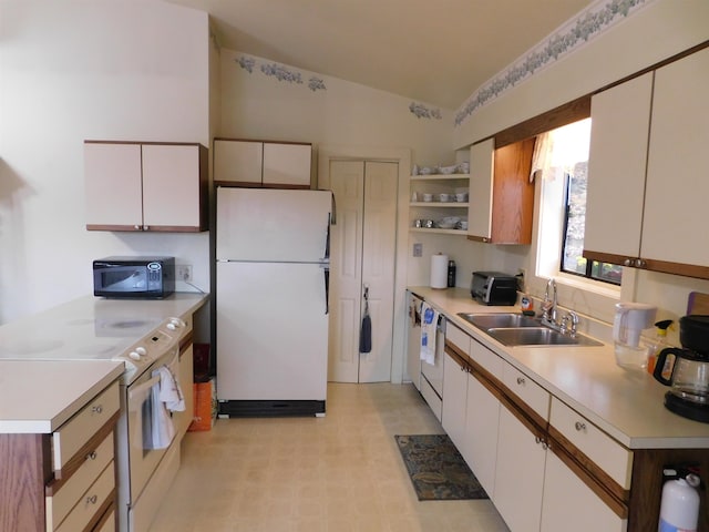 kitchen with white cabinets, white appliances, sink, and lofted ceiling