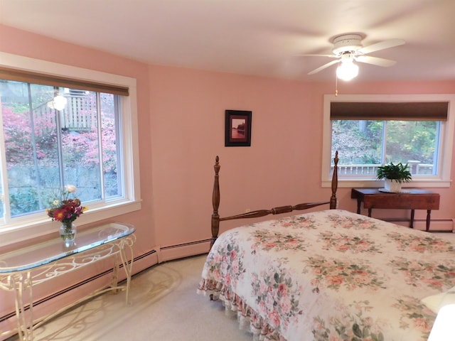 bedroom with ceiling fan, multiple windows, light carpet, and baseboard heating