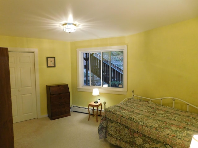 carpeted bedroom featuring a baseboard radiator and a closet